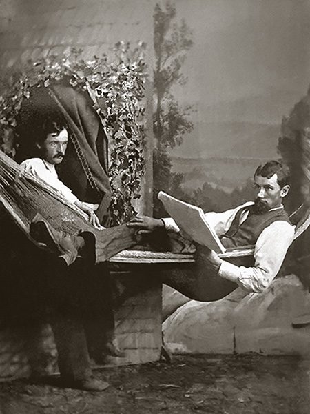 A studio photograph<br />
of two well-dressed gentlemen<br />
holding bowler hats,<br />
called derby hats in the USA.<br />
Probably late 1800s.<br />
One man has his hand<br />
on the other man’s shoulder.